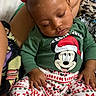 Keauni is registered to the contest to win money with this photo: baby, sleeping, child, pajamas, mickey_mouse, holiday_clothing, red_bows, person, lap, blanket, patterned_clothing, cute, indoors, resting, infant, hands, feet, fabric, comfort, cozy
