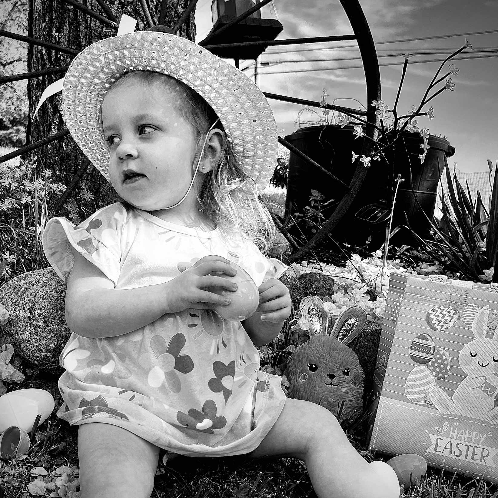 Isabella is registered to the contest to win money with this photo: baby, bonnet, cap, clothing, egg, face, food, hat, head, machine, person, photography, plant, portrait, pottedplant, sitting, summer, sunhat, toy, wheel