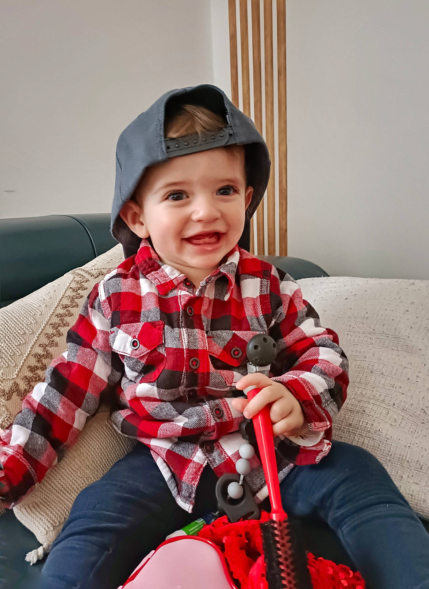 Aris participe au concours pour gagner de l'argent avec cette photo : baby, baseballcap, bodypart, cap, clothing, coat, couch, face, finger, furniture, hand, happy, hat, head, pants, person, photography, portrait, sitting, smile