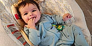 Ryland joined the competition — help win amazing prizes! baby, infant, baby_seat, smiling, blue_onesie, toy, fingers_in_mouth, happy, indoor, flooring, wood_floor, cushion, child, person, face, head, home, foot, soft_toy, comfort