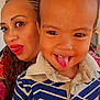 toddler, child, woman, face, tongue_out, close_up, portrait, smile, braids, red_lipstick, indoor, patterned_shirt, fun, playful, person, clothing, happy, expression, skin, head