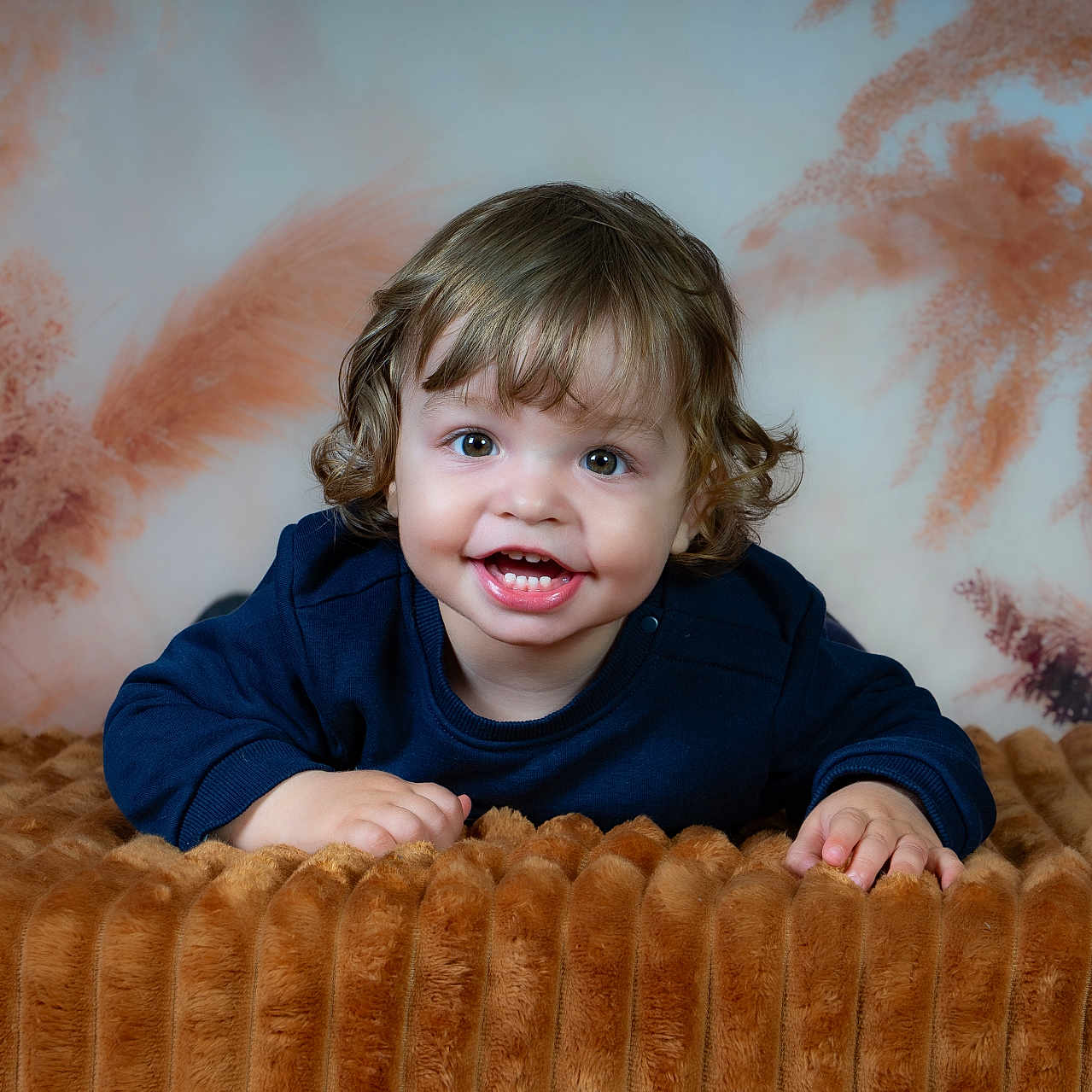 Mattéo a rejoint le concours — aidez-le/la à gagner de superbes lots ! toddler, child, smiling, curly_hair, blue_sweater, blanket, brown, soft_texture, portrait, indoor, happy, face, cute, baby, young_child, background, warm_colors, cozy, hands, expression
