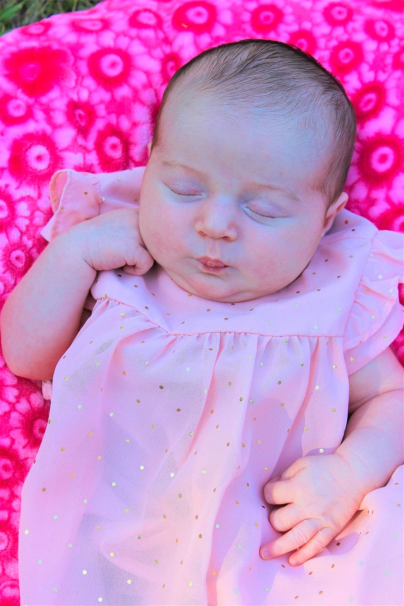 Juliet is registered to the contest to win money with this photo: arm, baby, baby_toddler_clothing, cheek, clothing, dress, face, facial_expression, finger, hand, happy, head, lip, person, pink, product, purple, skin, sleeve, textile