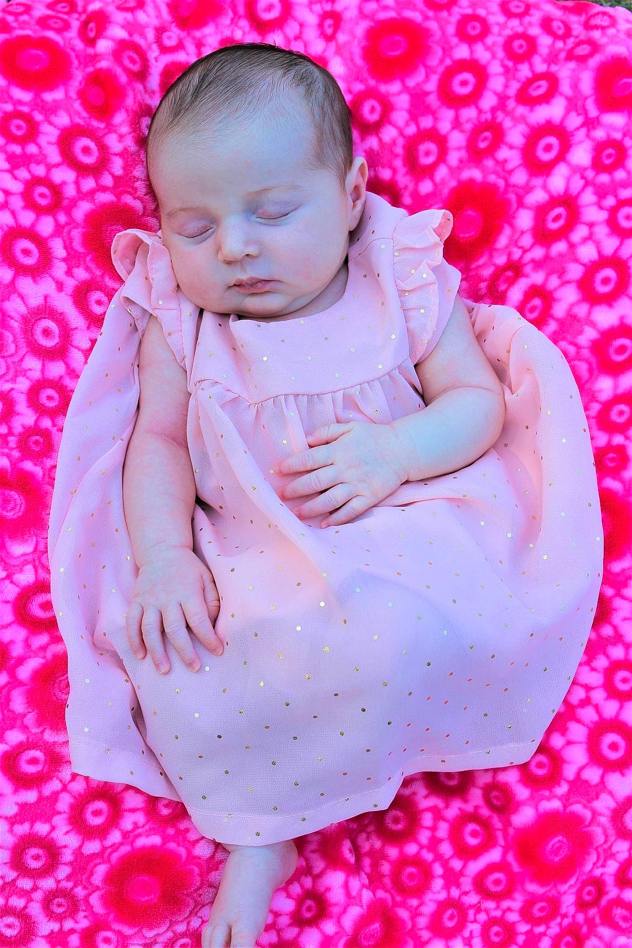 Juliet joined the competition — help win amazing prizes! arm, baby, baby_toddler_clothing, beauty, child, finger, flash_photography, gesture, grass, hand, happy, magenta, nail, pattern, person, pink, purple, red, skin, textile