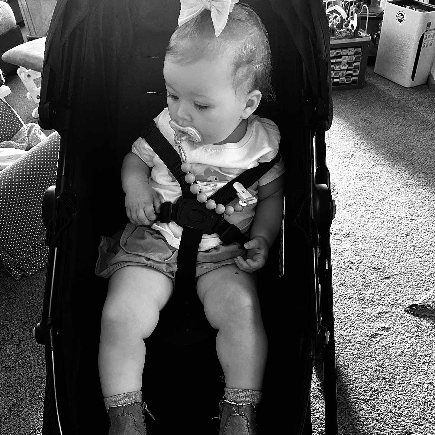 Abigail joined the competition — help win amazing prizes! baby, black_and_white, boots, bow, car_seat, carpet, child, curious, floor, furniture, home, indoor, pacifier, safety_harness, seated, shirt, shorts, stroller, toddler, toy