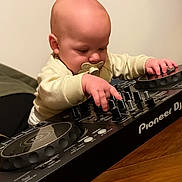 Isaac a rejoint le concours — aidez-le/la à gagner de superbes lots ! baby, pacifier, dj_controller, music, indoor, child, infant, hands, table, concentration, technology, pioneer_dj, cute, young_child, playing, electronic, device, music_equipment, person, wooden_table