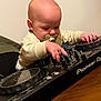 baby, pacifier, dj_controller, music, indoor, child, infant, hands, table, concentration, technology, pioneer_dj, cute, young_child, playing, electronic, device, music_equipment, person, wooden_table