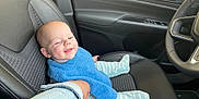 Isaac participe au concours pour gagner de l'argent avec cette photo : baby, child, car_interior, car_seat, blue_bib, striped_pajamas, hand_holding, denim_jacket, red_nail_polish, smiling, person, seat, steering_wheel, black_leather, door_panel, window_controls, happy, infant, young_child, portrait