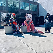 Cirrus joined the competition — help win amazing prizes! animal, building, casual, concrete_stool, costume, daytime, dog, furry_costume, glasses, group, mask, outdoor, person, pet, plaza, shadow, sidewalk, sunlight, tree, urban