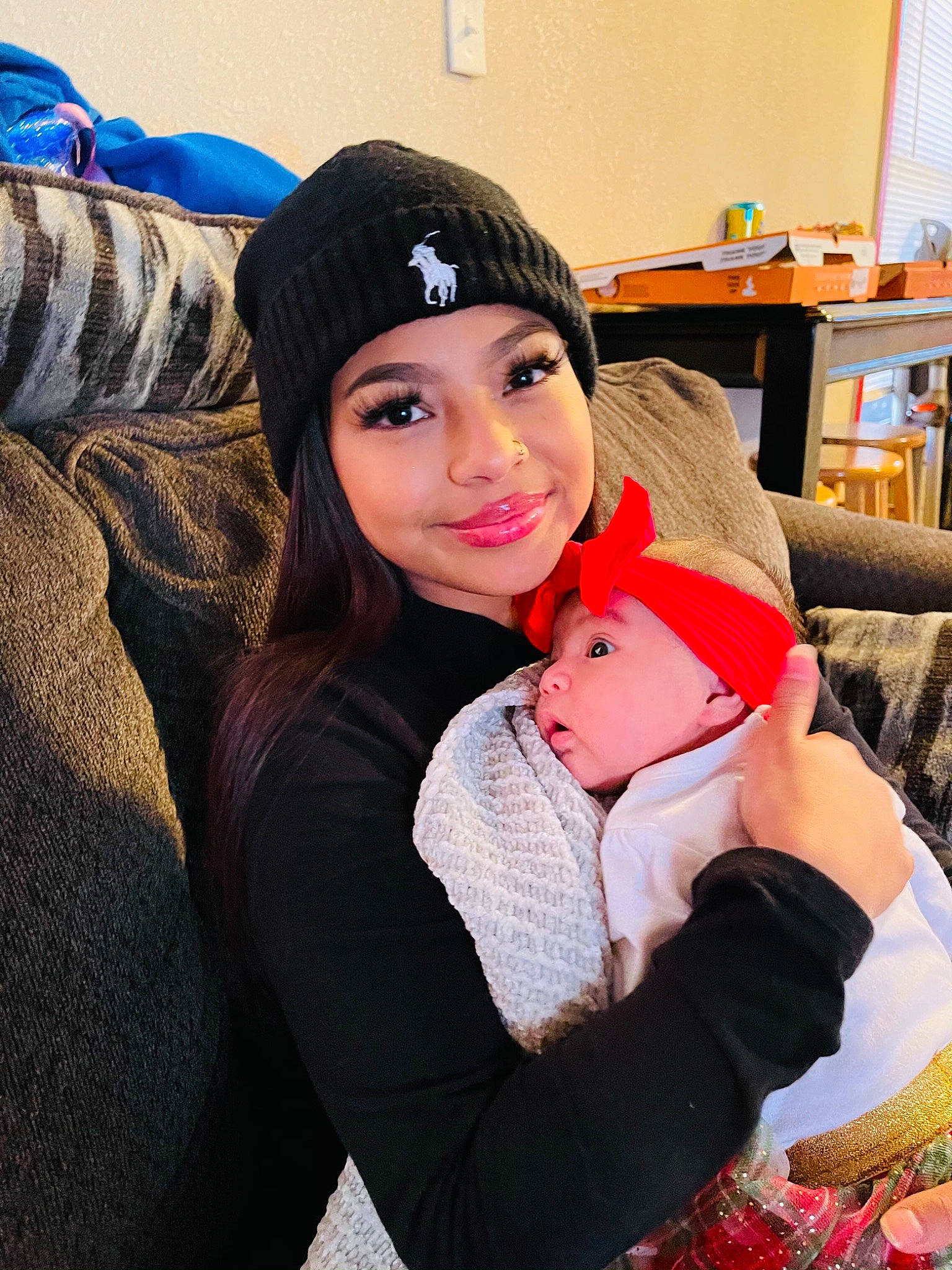 Ailani joined the competition — help win amazing prizes! baby, baby_toddler_clothing, beanie, bonnet, bookcase, comfort, family, headwear, joy, knit_cap, love, person, selfie, shelf, sweater, toddler, window_blind, winter, wool, woolen