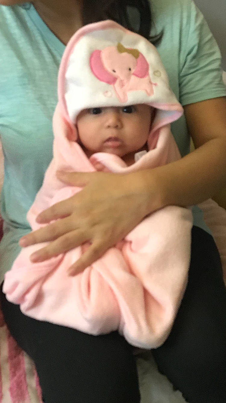 Ailani is registered to the contest to win money with this photo: baby, baby_toddler_clothing, cheek, child, comfort, elbow, finger, flesh, headwear, linens, person, pink, skin, sleeve, stomach, toddler