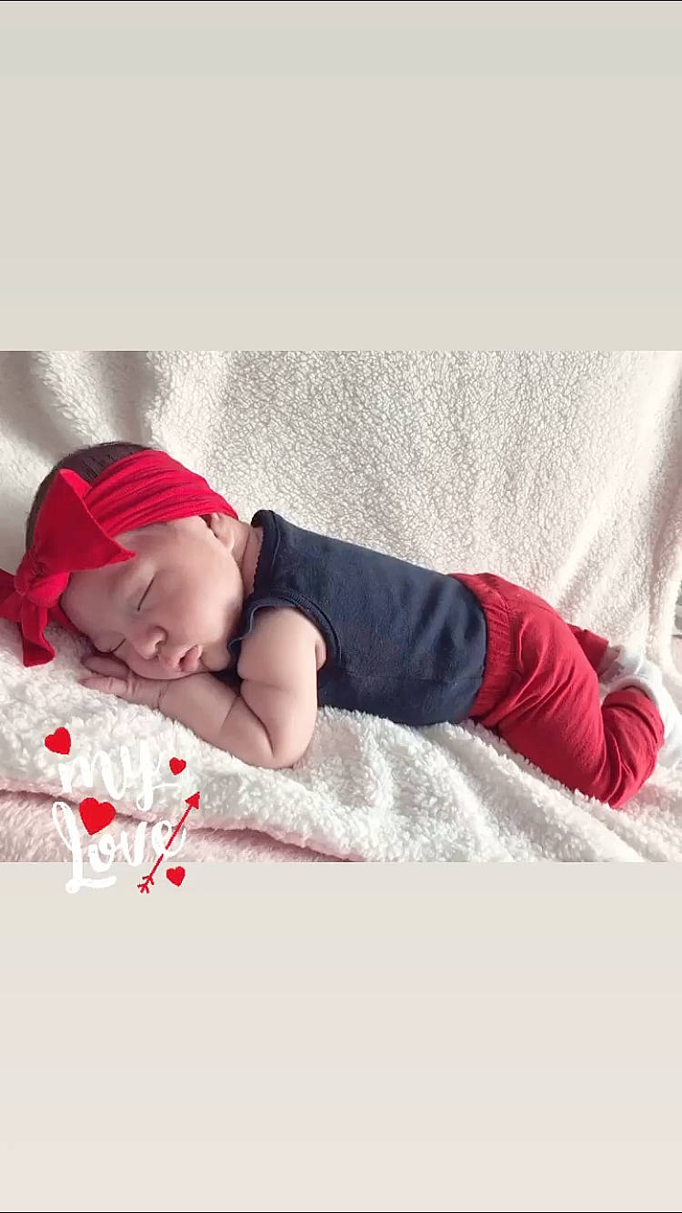 Ailani joined the competition — help win amazing prizes! baby, baby_sleeping, baby_toddler_clothing, bedding, bedtime, blanket, bonnet, comfort, costume_accessory, flesh, headwear, linens, mammal, nap, person, photo_shoot, portrait_photography, red, sleep