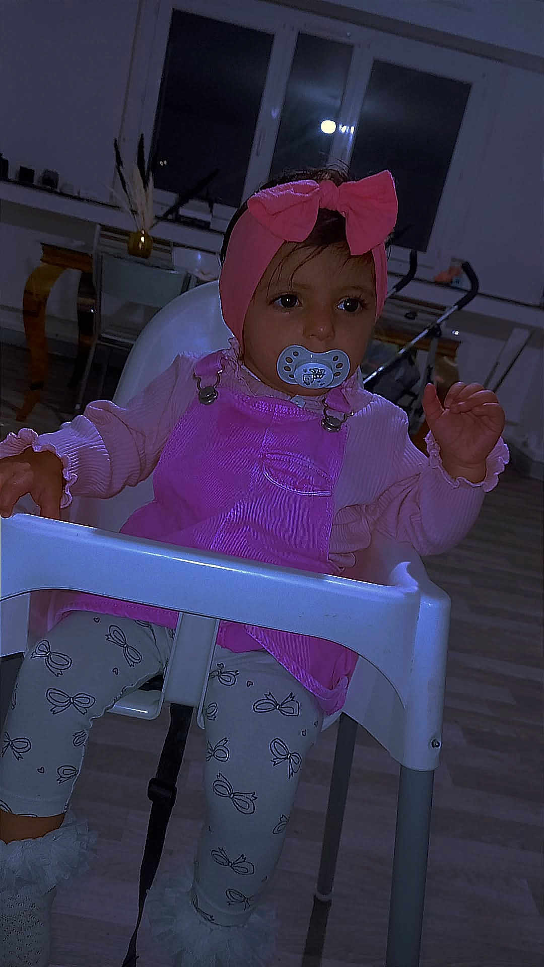 Bergula participe au concours pour gagner de l'argent avec cette photo : baby_clothes, child, curious, face, flooring, furniture, headband, high_chair, home, indoor, leggings, pacifier, patterned_clothing, person, pink_bow, sitting, stroller, toddler, window, young_child