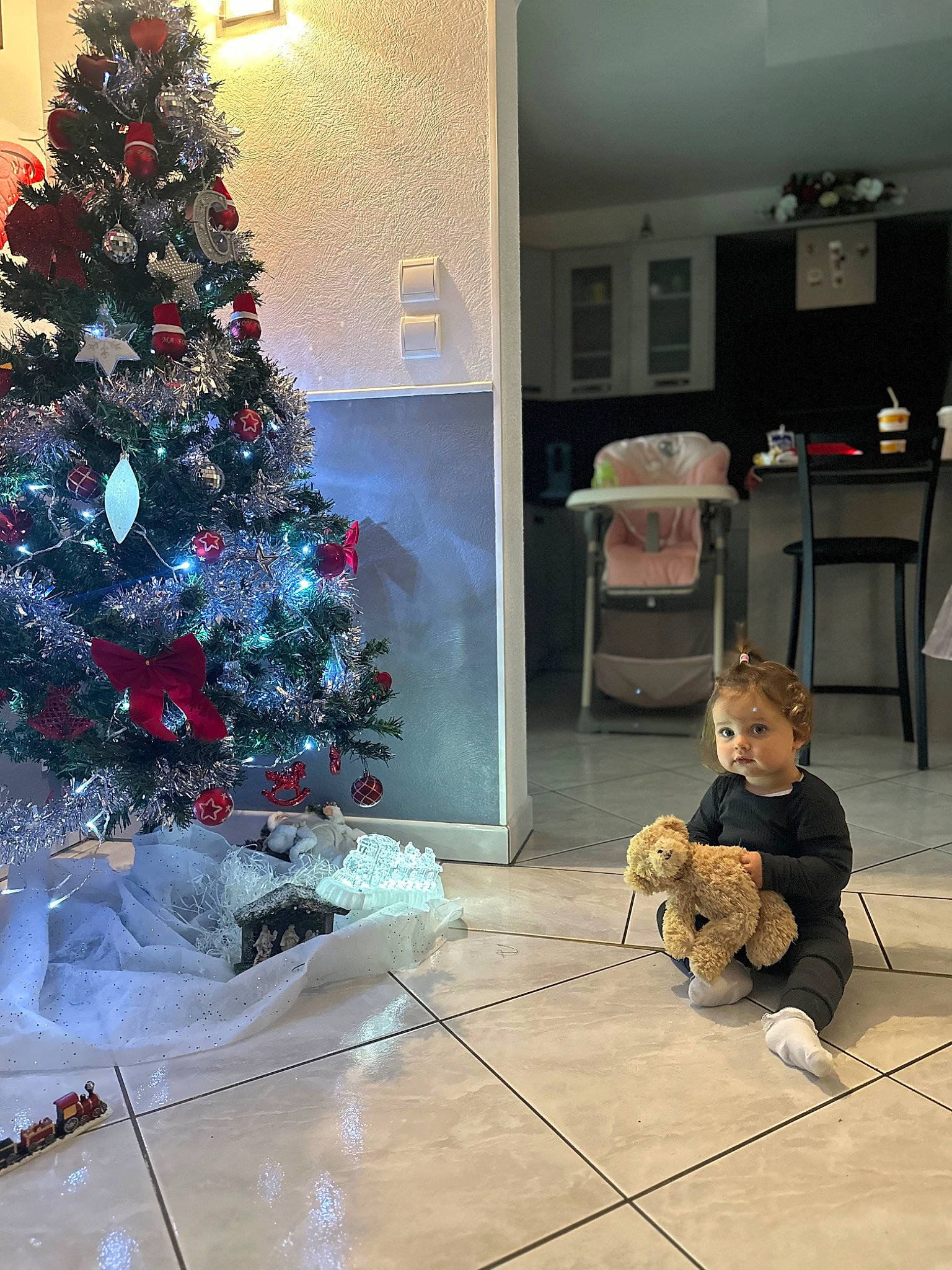 Giulia participe au concours pour gagner de l'argent avec cette photo : christmas_decoration, christmas_ornament, christmas_tree, companion_dog, event, evergreen, flooring, holiday_ornament, interior_design, light, lighting, living_room, ornament, person, plant, property, tints_and_shades, toy, tree, wall