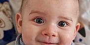 Lenny participe au concours pour gagner de l'argent avec cette photo : baby, bib, child, close_up, clothing, cute, drool, expression, eyes, face, hair, indoors, infant, mohawk, pattern, person, portrait, smile, soft_background, young