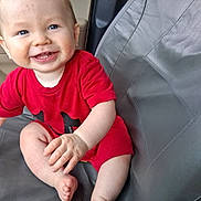 Leeham joined the competition — help win amazing prizes! baby, child, smiling, red_clothing, blue_eyes, sitting, seat, cushion, indoor, happy, cute, infant, portrait, skin, hand, foot, person, one_person, casual, young_child