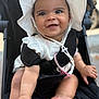 baby, child, smiling, stroller, white_hat, outdoor, cute, happy, infant, portrait, baby_clothing, black_stroller, feet, hands, sun_hat, closeup, seatbelt, baby_face, baby_pose, daylight