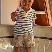 Konrad a rejoint le concours — aidez-le/la à gagner de superbes lots ! toddler, child, person, standing, striped_shirt, polo_shirt, denim_shorts, ripped_shorts, sneakers, white_shoes, couch, indoor, wood_paneling, smiling, short_hair, cute, fashion, casual_clothing, young_child, confident