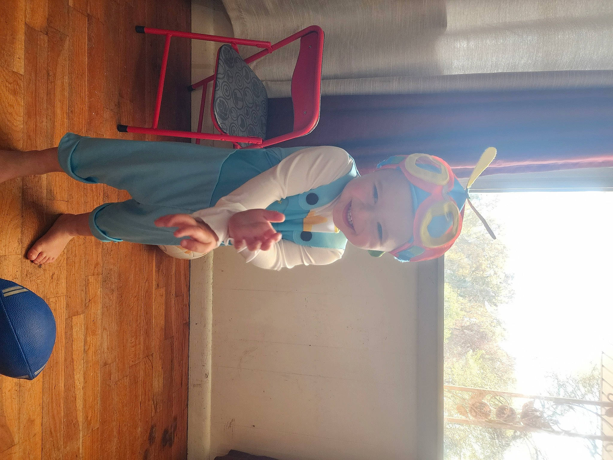 Brandon is registered to the contest to win money with this photo: ceiling, child, door, elbow, electric_blue, flooring, foot, fun, hardwood, headwear, human_leg, joy, knee, person, room, smile, thigh, toddler, toy, varnish