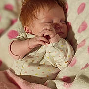 Hope is registered to the contest to win money with this photo: newborn, baby, infant, sleeping, sleepy, red_hair, face, hands, onesie, blanket, pink, polka_dots, bed, indoors, portrait, close_up, cozy, resting, child, photography