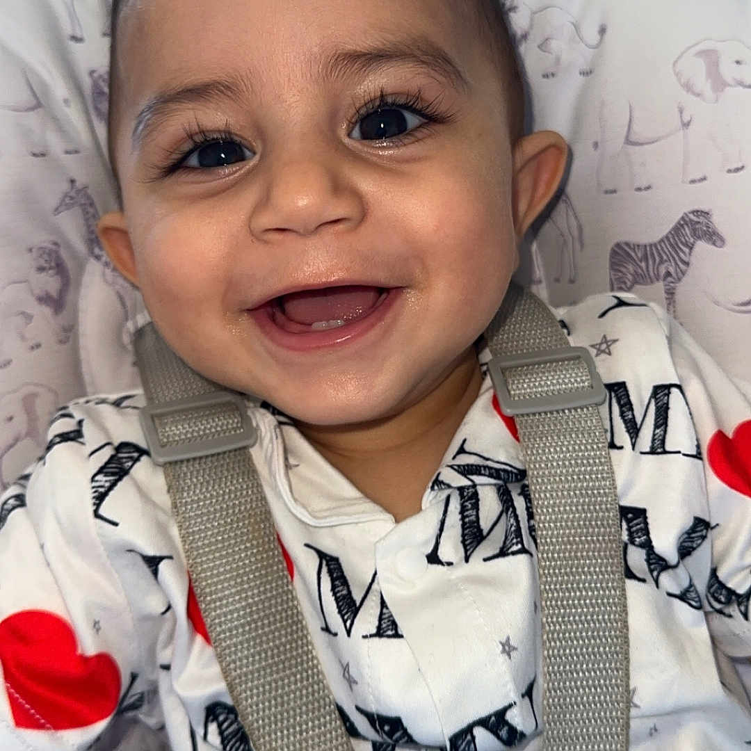 Waleed is registered to the contest to win money with this photo: accessories, animal, baby, babylaughing, belt, clothing, coat, cushion, face, happy, head, jacket, laughing, person, photography, portrait, smile, strap, vest, zebra