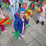 Célia participe au concours pour gagner de l'argent avec cette photo : children, costumes, masks, outdoor, pavement, colorful, playful, group, kids, bird_costume, feathers, handmade, jackets, shoes, parade, event, friends, crafts, fun, daytime