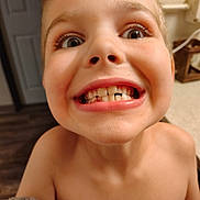 Hunter is registered to the contest to win money with this photo: child, face, smile, teeth, goofy, close_up, indoor, kitchen, countertop, expression, mouth, eyes, skin, person, young, funny_face, tooth_gap, casual, human, playful
