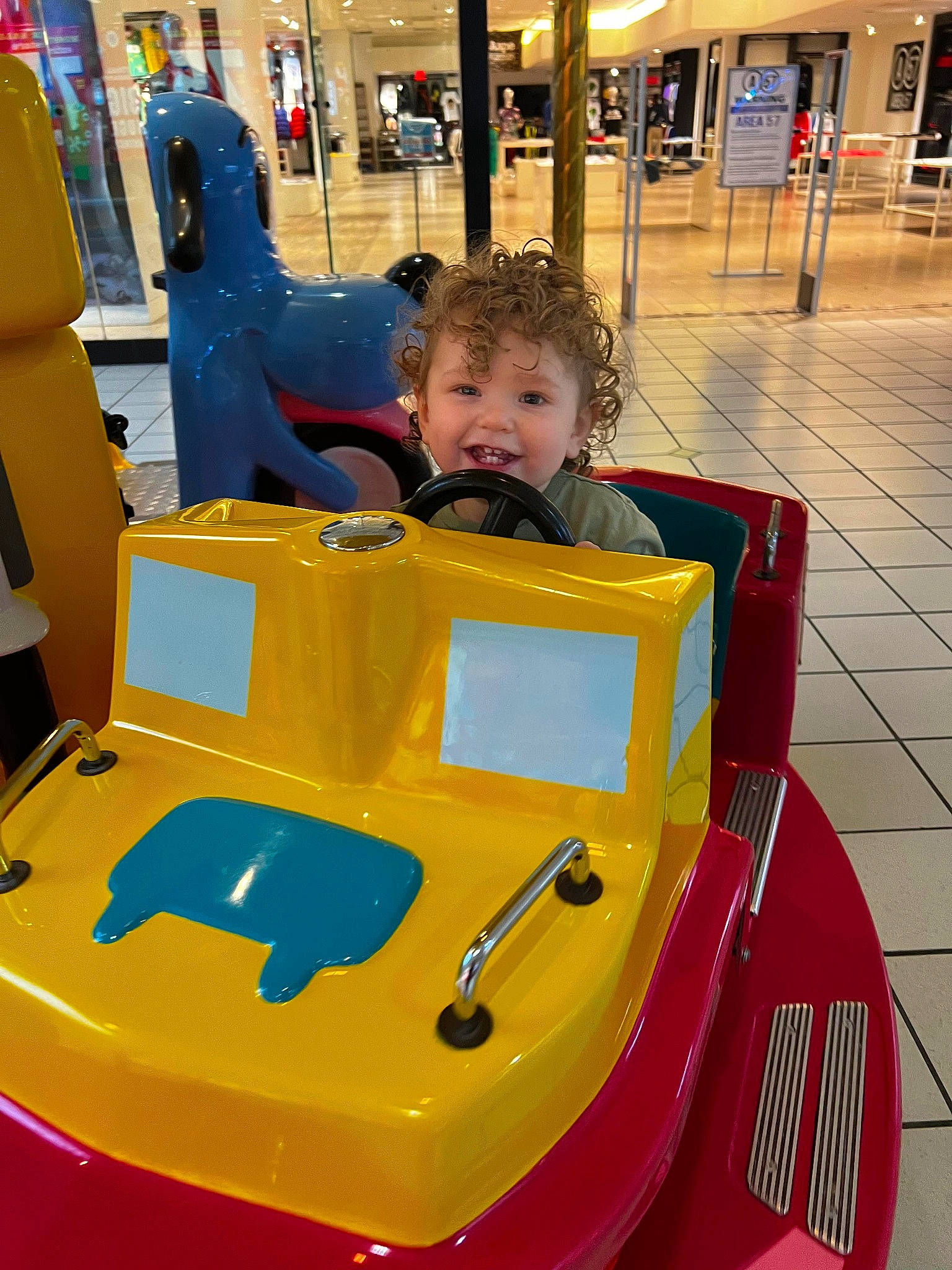Jaxson is registered to the contest to win money with this photo: automotive_design, baby, child, fun, human_settlement, leisure, motor_vehicle, people, person, photograph, public_space, recreation, riding_toy, smile, snapshot, tire, toddler, travel, vehicle, wheel