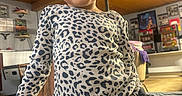 Tre'Me is registered to the contest to win money with this photo: child, toddler, smiling, leopard_print, shirt, curly_hair, indoor, living_room, furniture, couch, decorations, portrait, happy, person, casual_clothing, seated, young_child, cute, home, cozy