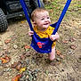 Nevaeh is registered to the contest to win money with this photo: baby, child, swing, outdoor, grass, leaves, yellow_clothing, blue_swing, happy, smiling, face, person, nature, tree, ground, toddler, play, fun, seasonal, autumn