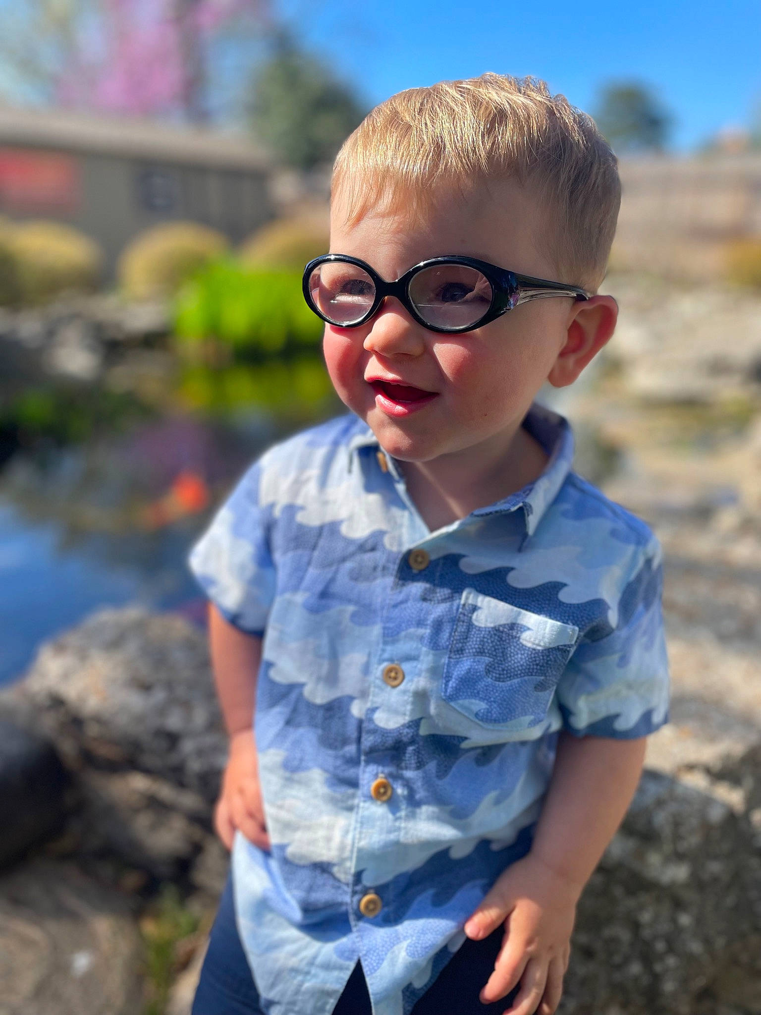 Brivon is registered to the contest to win money with this photo: chin, cool, eyewear, fun, glasses, goggles, grass, hair, happy, leaf, leisure, person, plant, sleeve, smile, sunglasses, sunlight, t_shirt, toddler, vision_care