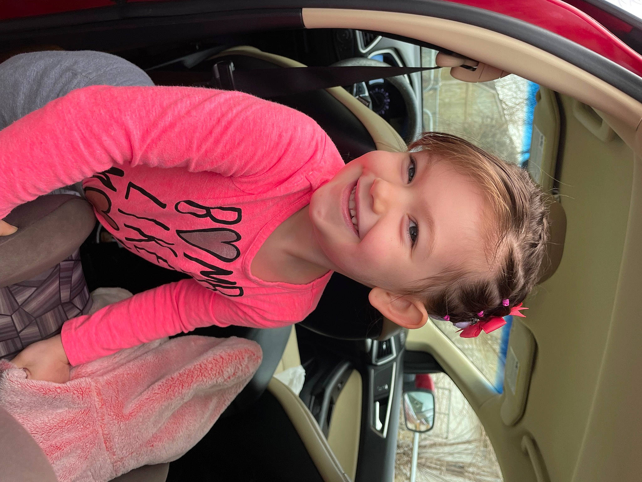 Peyton is registered to the contest to win money with this photo: auto_part, automotive_design, automotive_exterior, automotive_lighting, automotive_wheel_system, blond, car, car_seat, child, family_car, fun, joy, luxury_vehicle, motor_vehicle, mouth, person, rim, smile, steering_wheel, thigh
