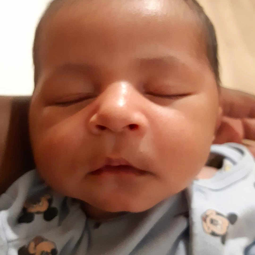 Maël participe au concours pour gagner de l'argent avec cette photo : baby, blue_clothing, cartoon_print, child, close_up, cute, eyelids, face, head, indoors, infant, mouth, newborn, peaceful, person, portrait, skin, sleeping, soft_lighting, young