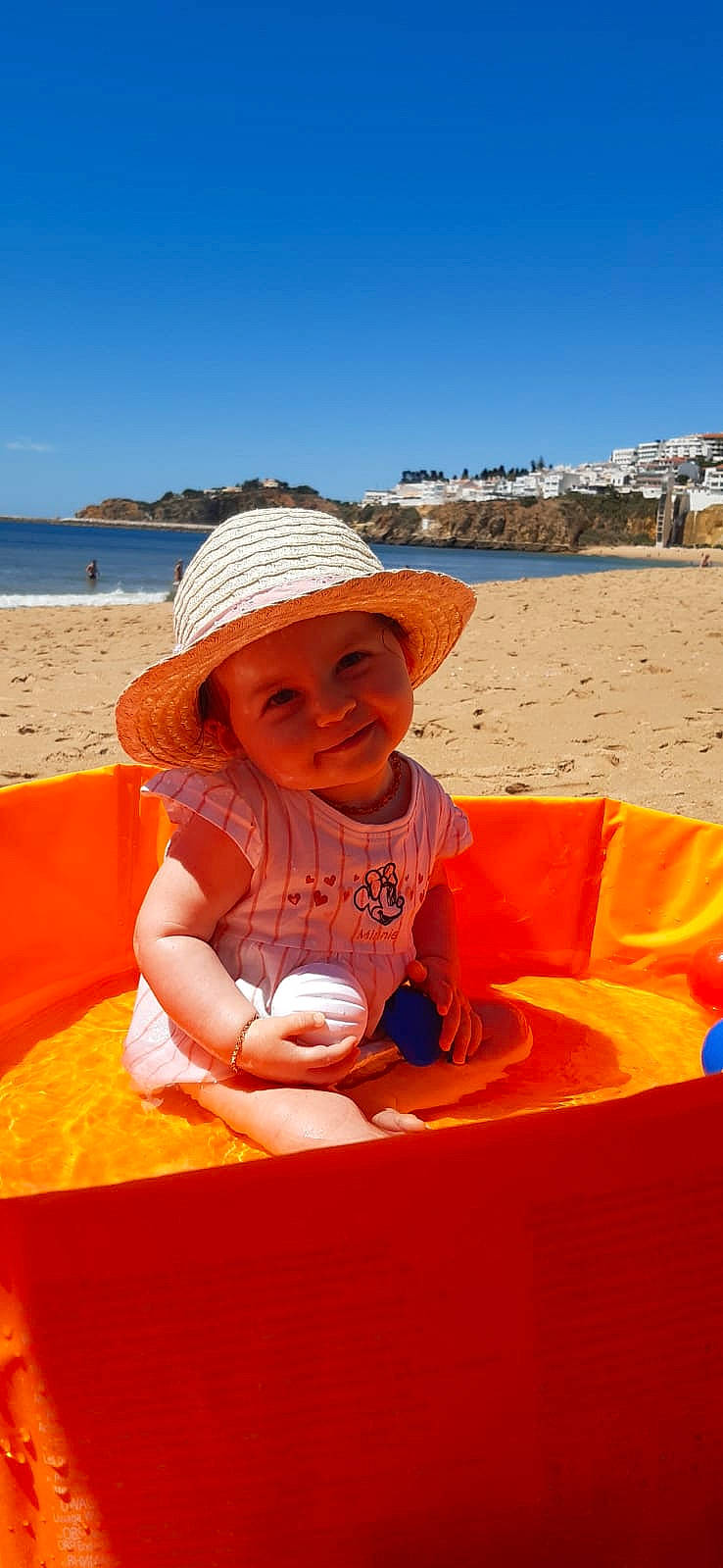 Joy participe au concours pour gagner de l'argent avec cette photo : baby, beach, body_of_water, fun, happy, hat, headwear, holiday, joy, leisure, people_on_beach, person, recreation, sand, shorts, sitting, sky, smile, summer, sun_hat
