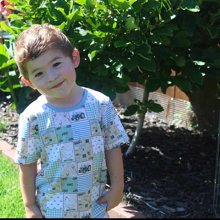 Tulson joined the competition — help win amazing prizes! child, boy, smiling, garden, plants, greenery, sunlight, outdoor, grass, flower_bed, tree, shirt, patterned_clothing, happy, young, nature, daylight, casual, portrait, playful