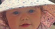 Evalyn is registered to the contest to win money with this photo: baby, infant, child, face, hat, floral_pattern, sunhat, outdoor, cute, portrait, closeup, pink, clothing, skin, eyes, cheeks, person, summer, sunlight, expression