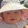 baby, infant, child, face, hat, floral_pattern, sunhat, outdoor, cute, portrait, closeup, pink, clothing, skin, eyes, cheeks, person, summer, sunlight, expression
