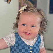 Evalyn is registered to the contest to win money with this photo: baby, child, smiling, blue_eyes, hair_clip, dress, checkered_pattern, floral_shirt, indoor, portrait, cute, happy, face, infant, person, butterfly, decoration, curly_hair, buttoned_dress, young