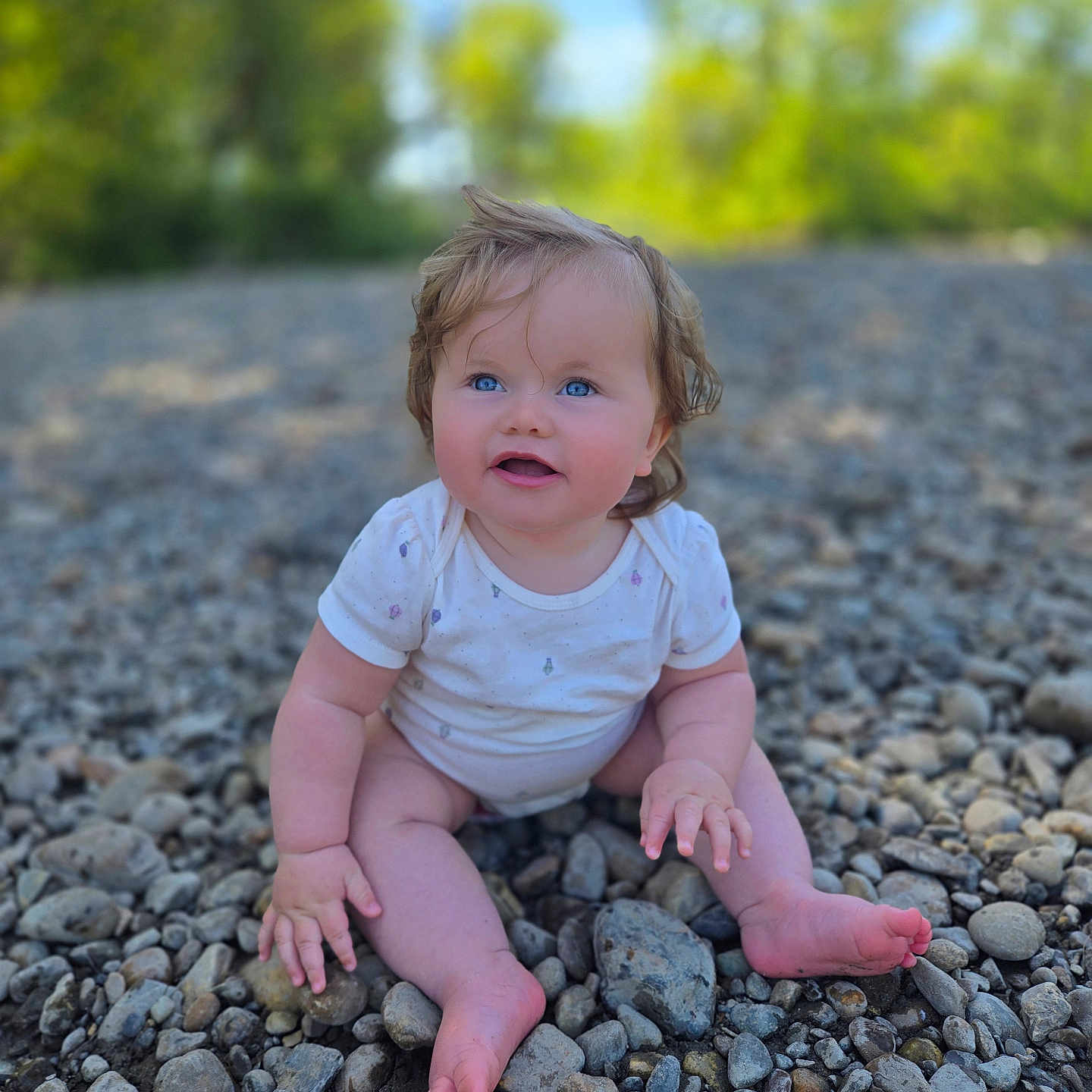 Evalyn joined the competition — help win amazing prizes! baby, child, sitting, outdoor, rocks, nature, blue_eyes, onesie, smiling, happy, cute, toddler, grass, sunlight, portrait, barefoot, hands, feet, face, background_blur