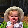 Evalyn joined the competition — help win amazing prizes! baby, child, grass, hat, sunhat, outdoor, purple_blanket, smiling, tongue_out, pointing, greenery, sunlight, cute, infant, nature, sitting, playful, portrait, happy, summer