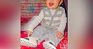 Kabir joined the competition — help win amazing prizes! baby, brick_wall, child, cute, floral_pattern, funny_face, graffiti, gray_clothing, happy, indoor, playful, portrait, red_blanket, sitting, smiling, star_pattern, toddler, tongue_out, white_shoes, winking