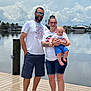 William joined the competition — help win amazing prizes! baby, casual_clothing, child, cloudy_sky, dock, family, footwear, holding, lake, man, outdoor, people, shorts, smile, summer, sunglasses, tattoo, tshirt, water, woman