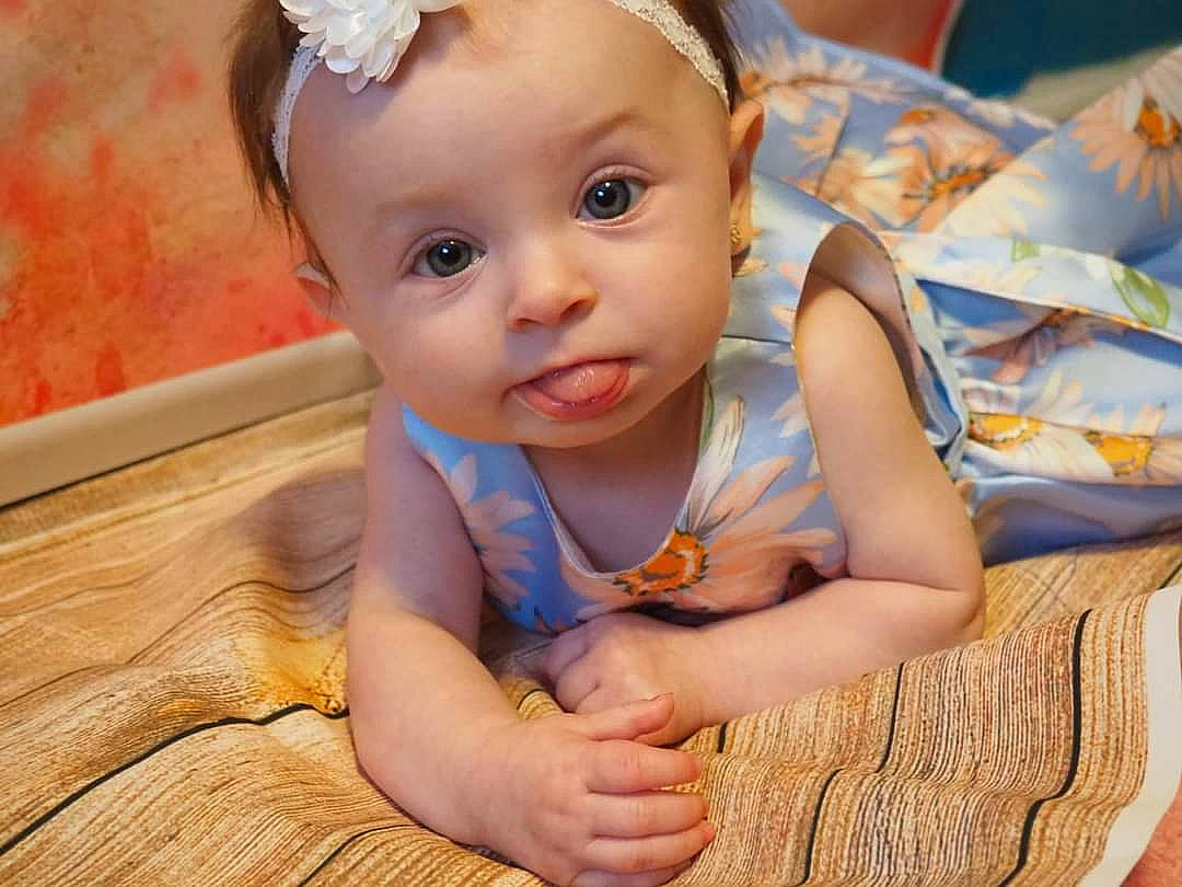 Dixie is registered to the contest to win money with this photo: baby, baby_toddler_clothing, blond, cheek, child, dress, eye, face, finger, flooring, fun, happy, hardwood, headband, headpiece, iris, nose, person, skin, toddler