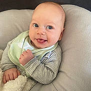 Thomas joined the competition — help win amazing prizes! baby, infant, smiling, blue_eyes, bib, striped_clothing, blanket, cushion, cozy, cute, child, face, hand, soft_texture, indoor, portrait, happy, skin, person, newborn