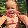 baby, child, infant, smiling, happy, portrait, outdoor, sunlight, park, lawn, fence, seated, pink_outfit, dress, ruffled_collar, cherry_detail, curly_hair, brown_eyes, close_up, photography