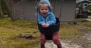 Emilena Joy joined the competition — help win amazing prizes! boots, bucket_swing, child, clothing, fall, fun, grass, happy, hoodie, joy, nature, outdoor, person, play, playground, shed, smiling, swing, toddler, trees