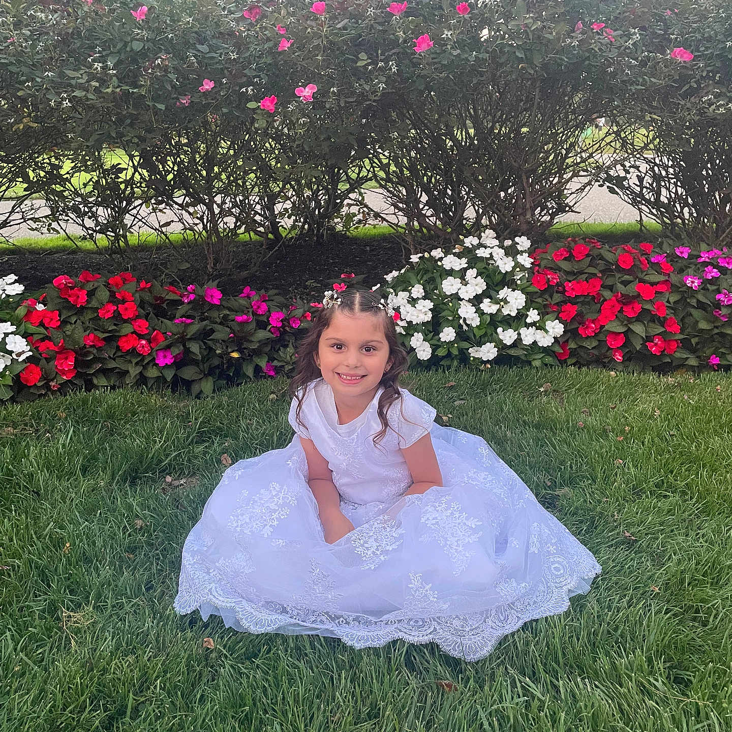 Valentina Rose is registered to the contest to win money with this photo: bushes, child, colorful, cute, daylight, flower_bed, flowers, garden, girl, grass, greenery, happy, nature, outdoor, portrait, pretty, sitting, smile, white_dress, young
