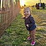 child, clothing, cute, daylight, fence, field, grass, hair, happy, nature, outdoor, person, playful, portrait, shoes, smiling, sunlight, sunset, toddler, young