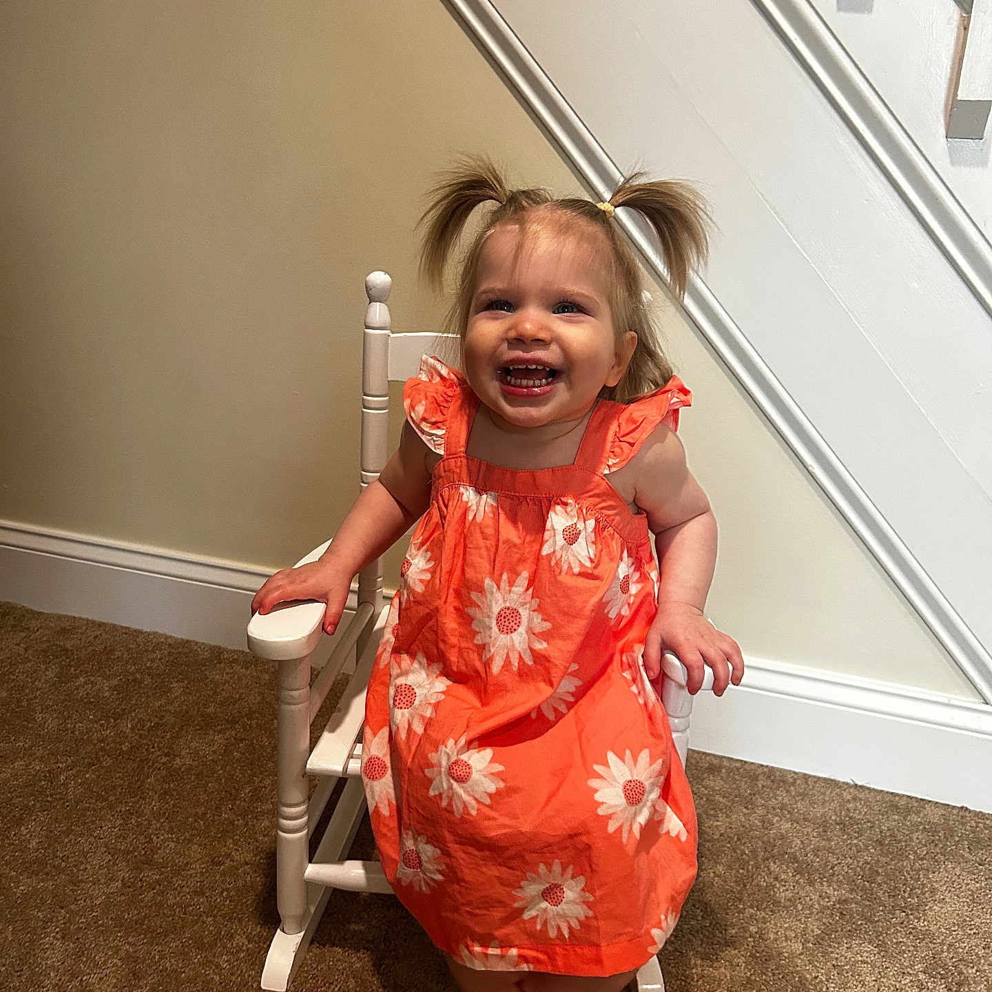 Briella Skye joined the competition — help win amazing prizes! toddler, child, smiling, pigtails, orange_dress, flower_pattern, rocking_chair, indoor, carpet, staircase, happy, cute, person, young_child, seated, home, playful, girl, furniture, portrait