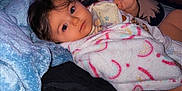 Mary is registered to the contest to win money with this photo: anime_pillow, baby, bed, blanket, child, clothing, comfort, cozy, curious, cute, face, furniture, indoor, looking, lying_down, pillow, portrait, room, soft, young_child